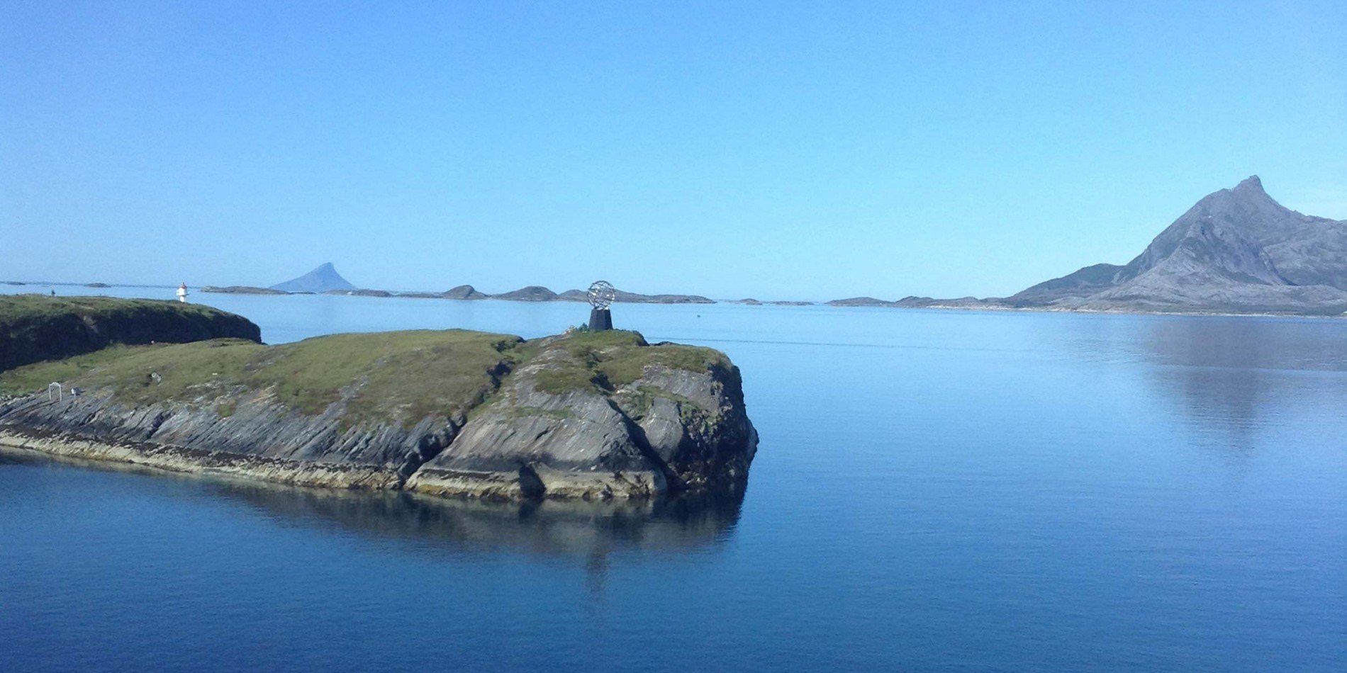 The Vikingen island with a lighthouse and the Arctic Circle monument
