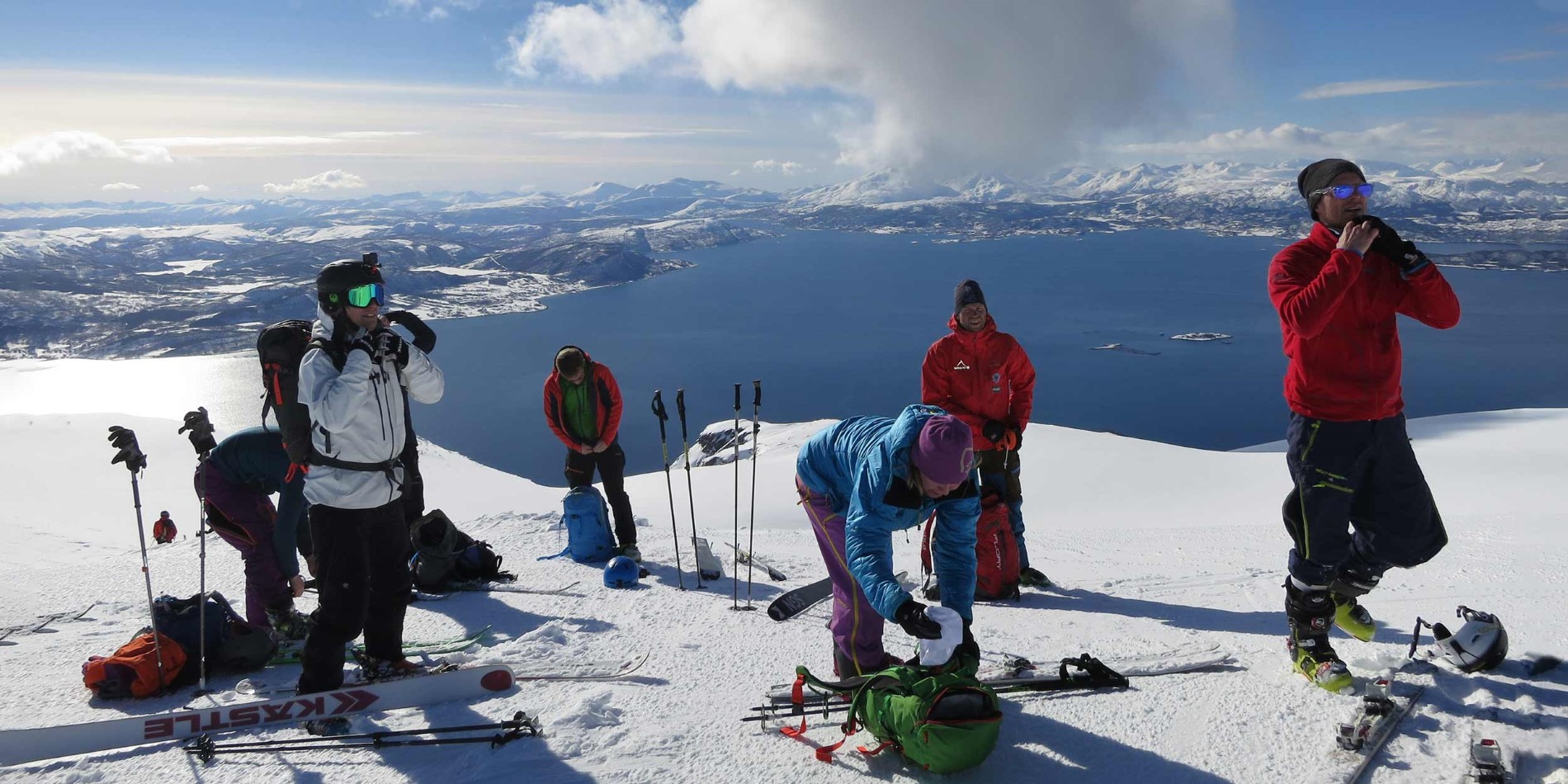A group of people riding skis on top of a snow covered mountain